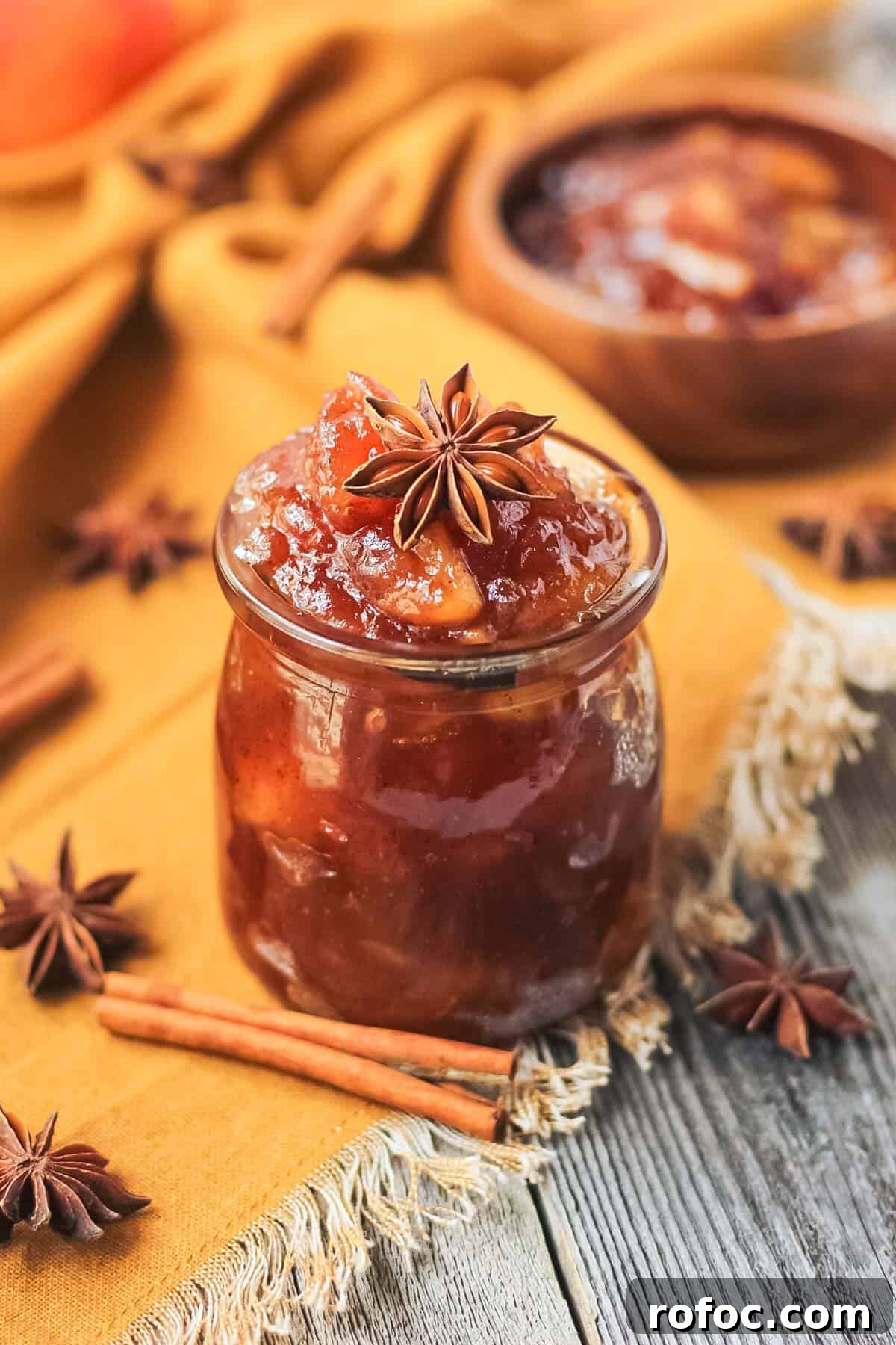 How to Make Classic Homemade Apple Jam: Simple Step-by-Step Recipe 5 apple jam in a glass jar sitting on a wooden surface.