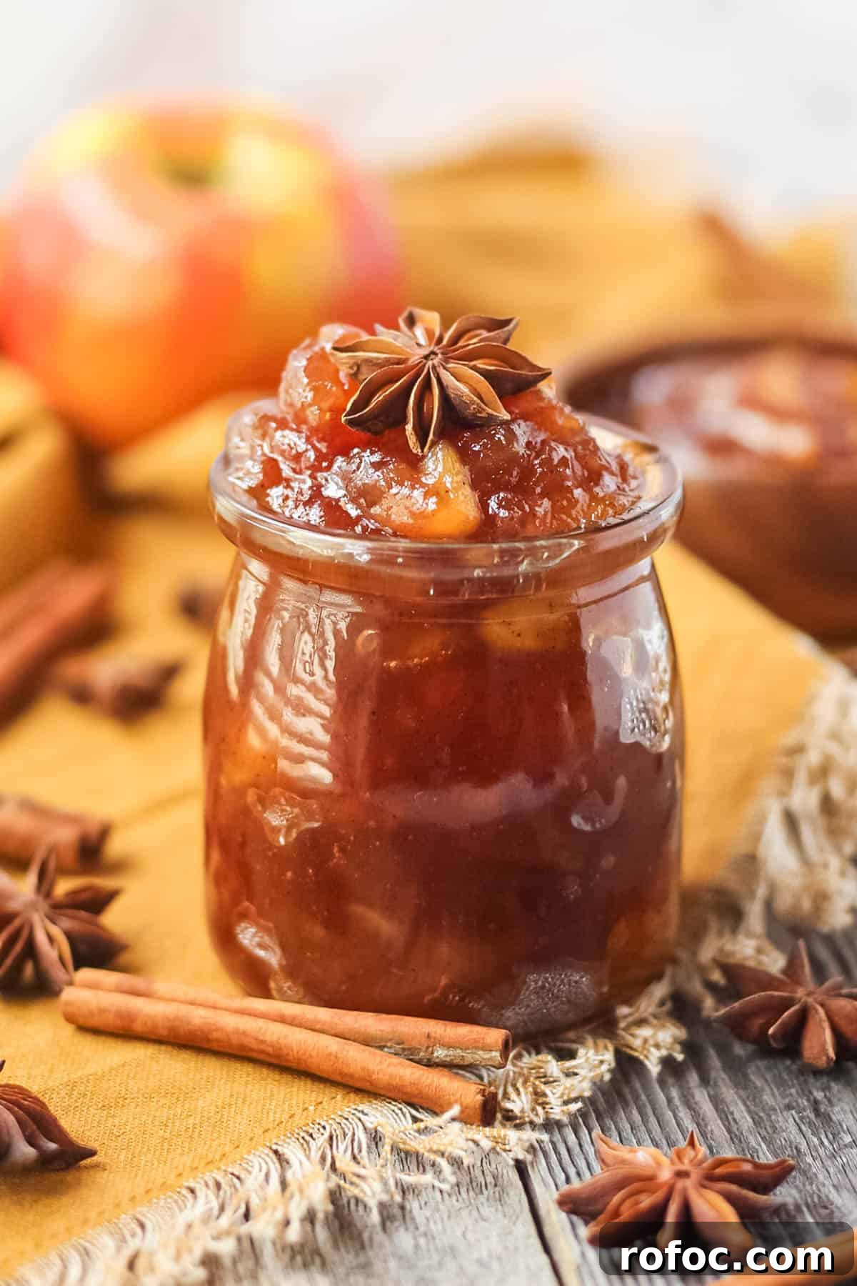 How to Make Classic Homemade Apple Jam: Simple Step-by-Step Recipe 6 apple jam in a glass jar sitting on a wooden surface.