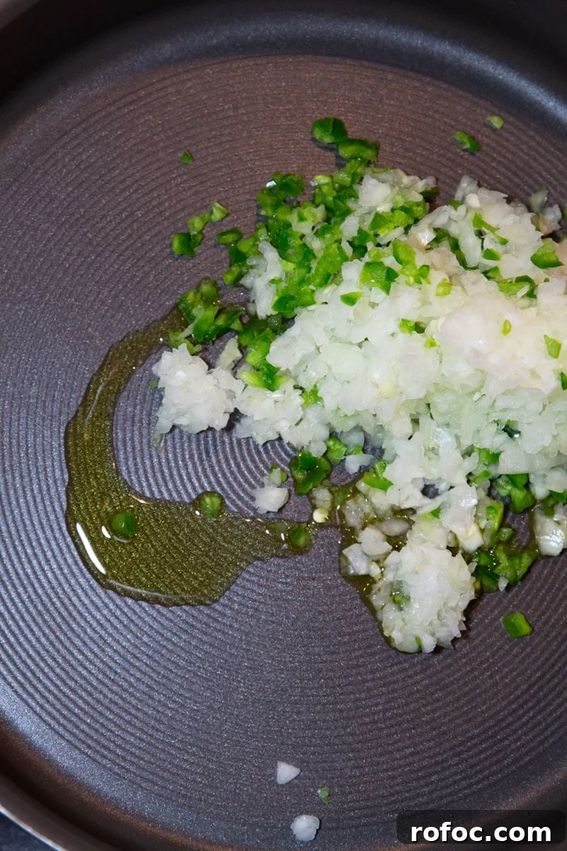 Sauteing jalapeno, garlic and onion in a skillet.