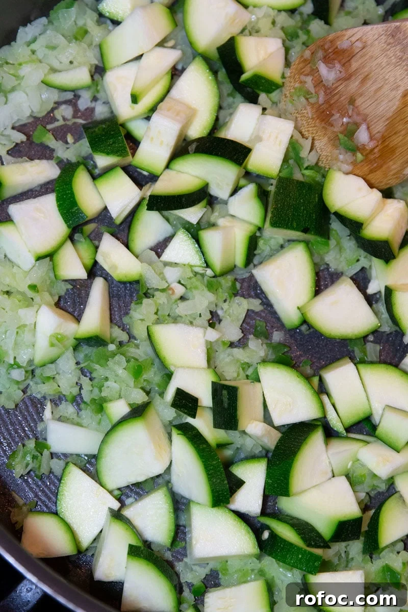 Sauteing fresh zucchini in a skillet.