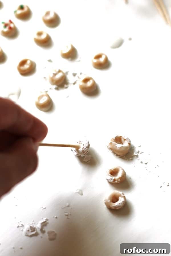 Magical Elf Donuts: Festive Donut Recipes & Decorating Ideas 5 Picking up the Elf Donuts with a toothpick to move them to dry