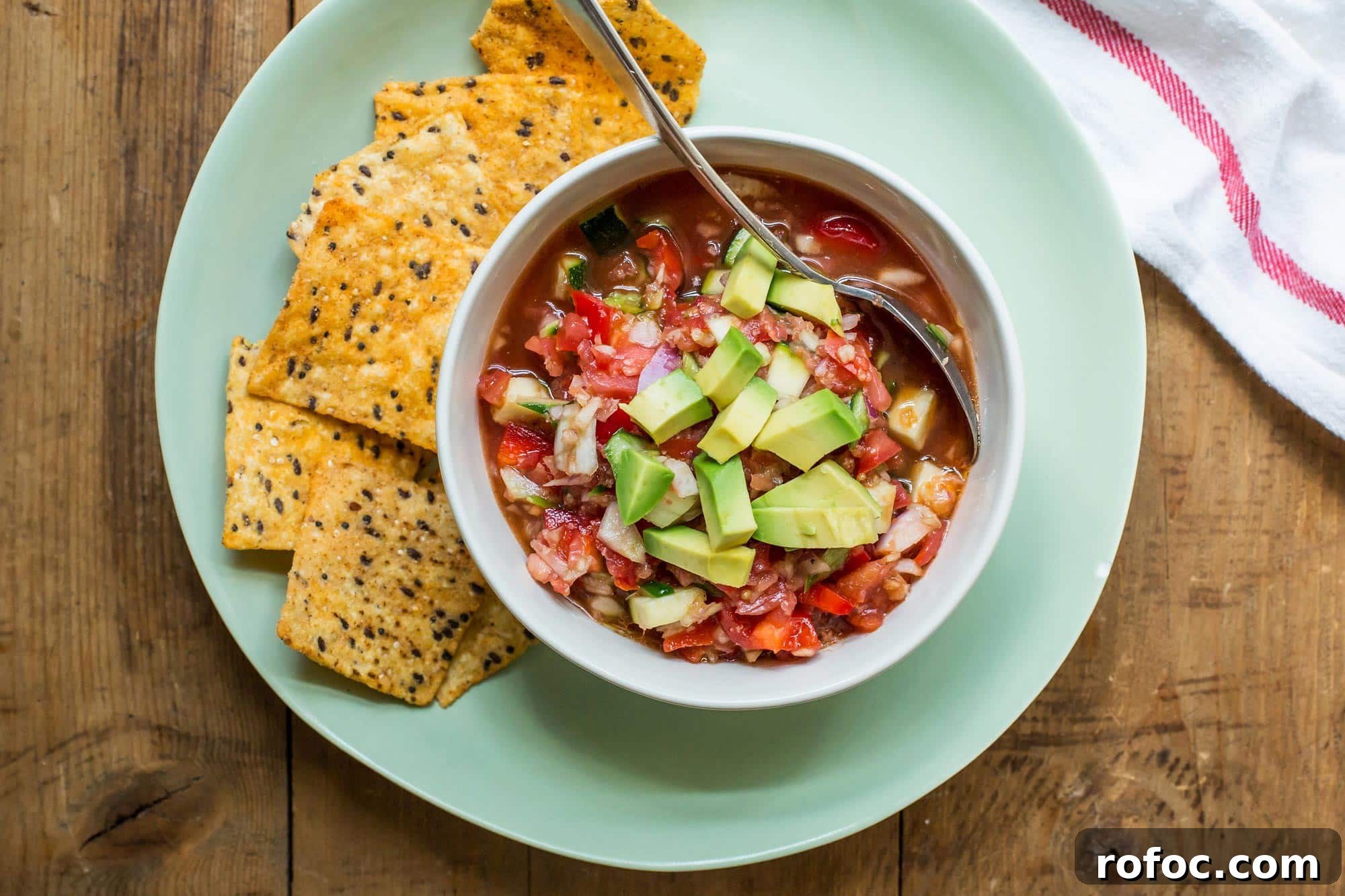 30 Refreshing No-Cook Summer Recipes for Hot Days 2 Gazpacho in bowl on plate with chips.