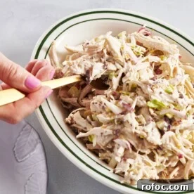 Scooping Chicken Salad out of bowl with fork.