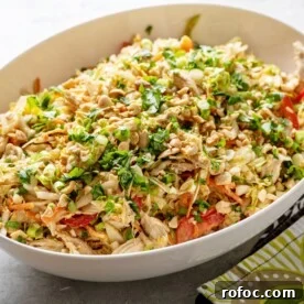 Indonesian Chicken Salad in white serving bowl on table.