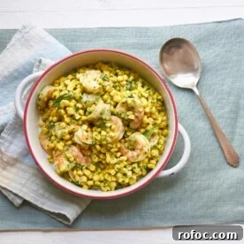 Spoon next to a bowl of Shrimp and Corn Salad with Basil Dressing.