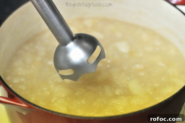 Purée apples Immersion blender in pan of apples