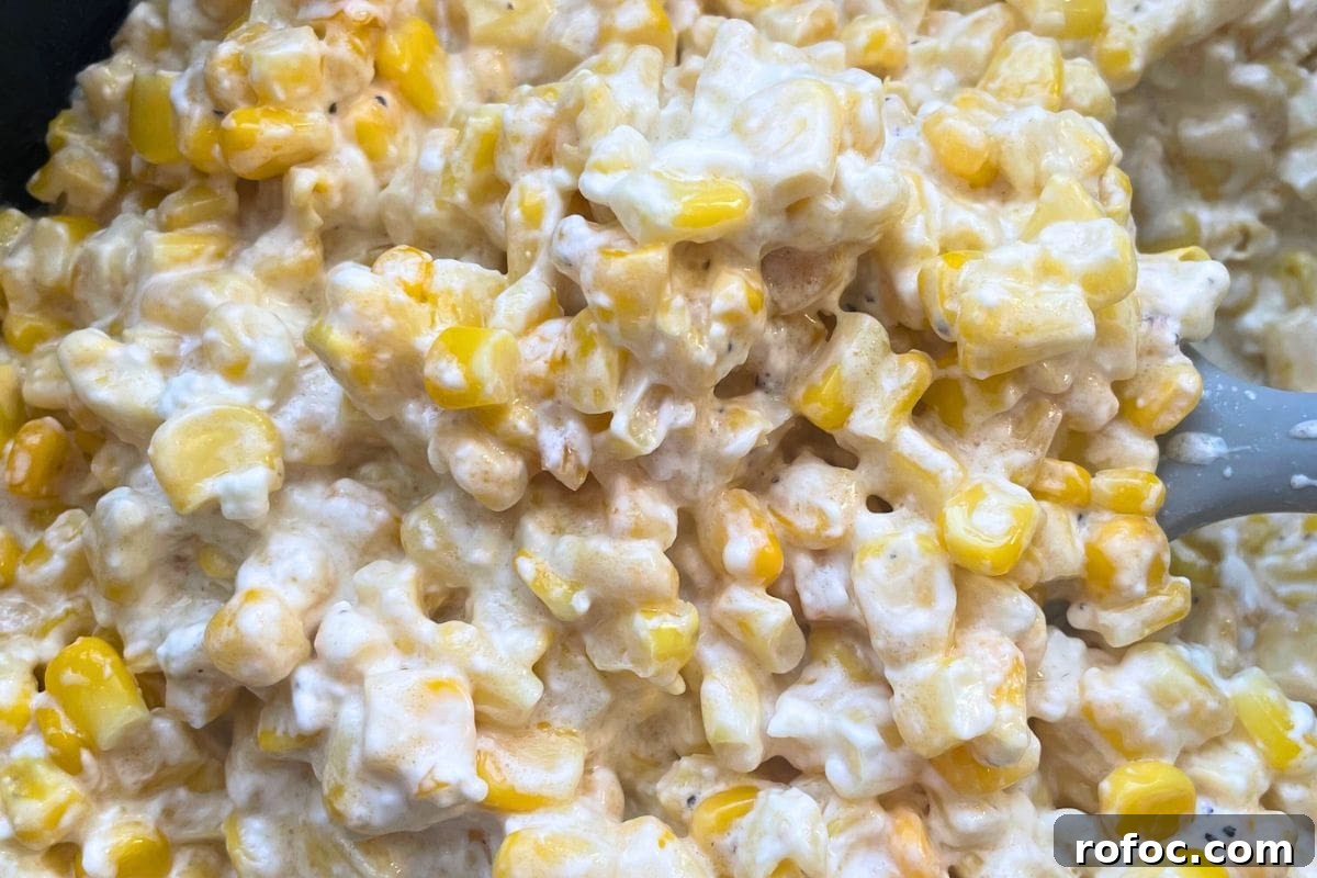 12 Delicious Easter Crockpot Recipes for a Stress-Free Holiday 4 Close-up image of a creamy corn casserole with visible kernels and a spoon.