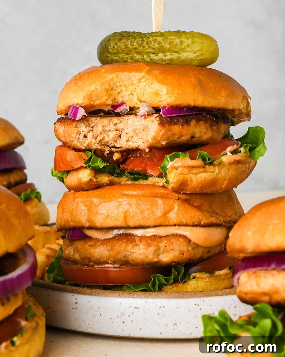 Juicy Turkey Burger Recipes for Flavorful Weeknight Meals 13 a stack of 2 Turkey Burgers, the top one has a bite taken out of it and a pickle on top