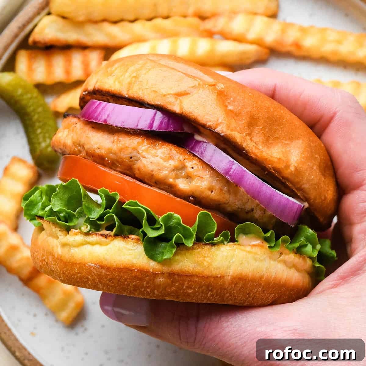 Juicy Turkey Burger Recipes for Flavorful Weeknight Meals 5 a hand holding a Turkey Burger on a bun