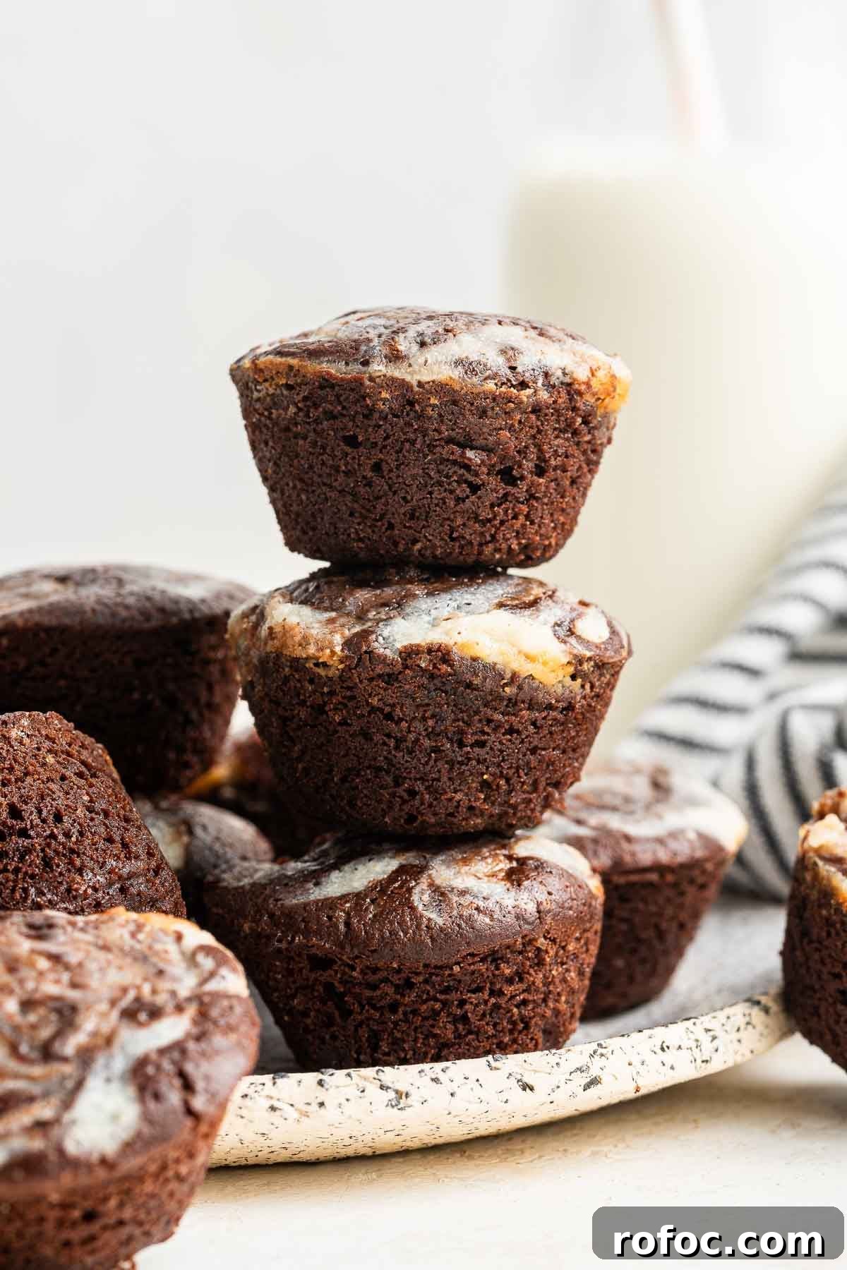 Cheesecake Brownie Bites: Mini Dessert Recipe for Parties 3 Three cheesecake brownie bites stacked on top of each other.