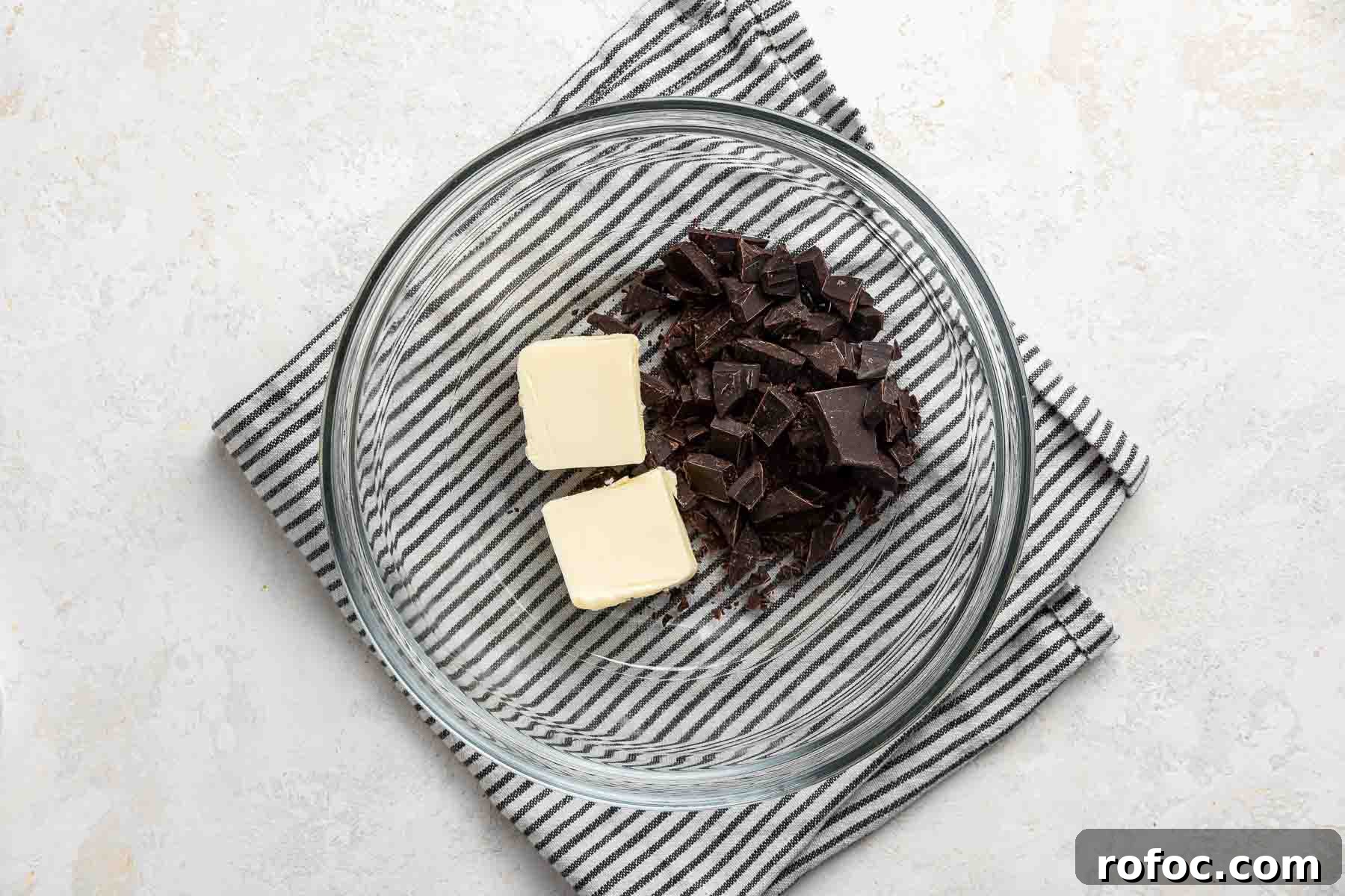Cheesecake Brownie Bites: Mini Dessert Recipe for Parties 5 Chopped semisweet chocolate and butter in a clear glass bowl.