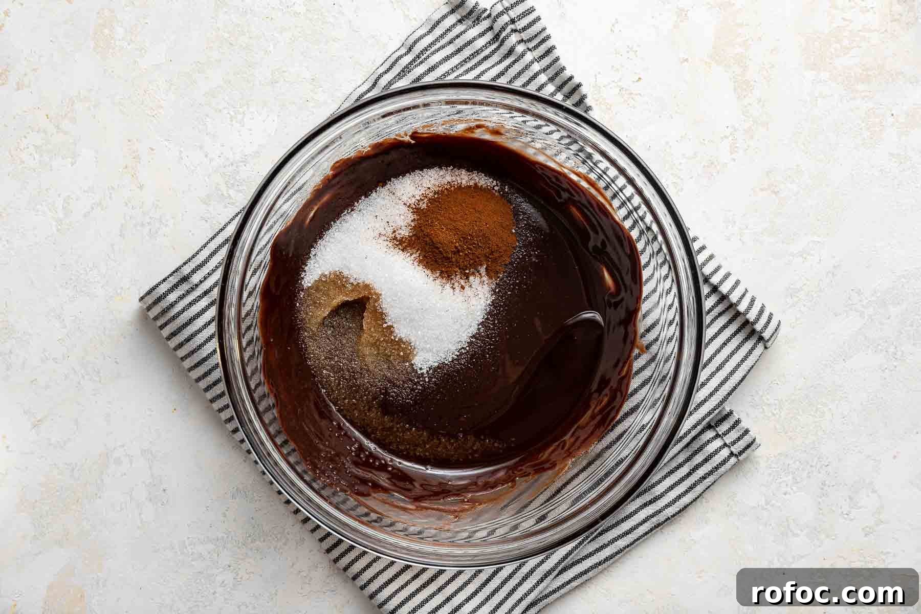 Cheesecake Brownie Bites: Mini Dessert Recipe for Parties 6 Stirring sugar, espresso powder and vanilla into raw brownie batter in glass bowl.