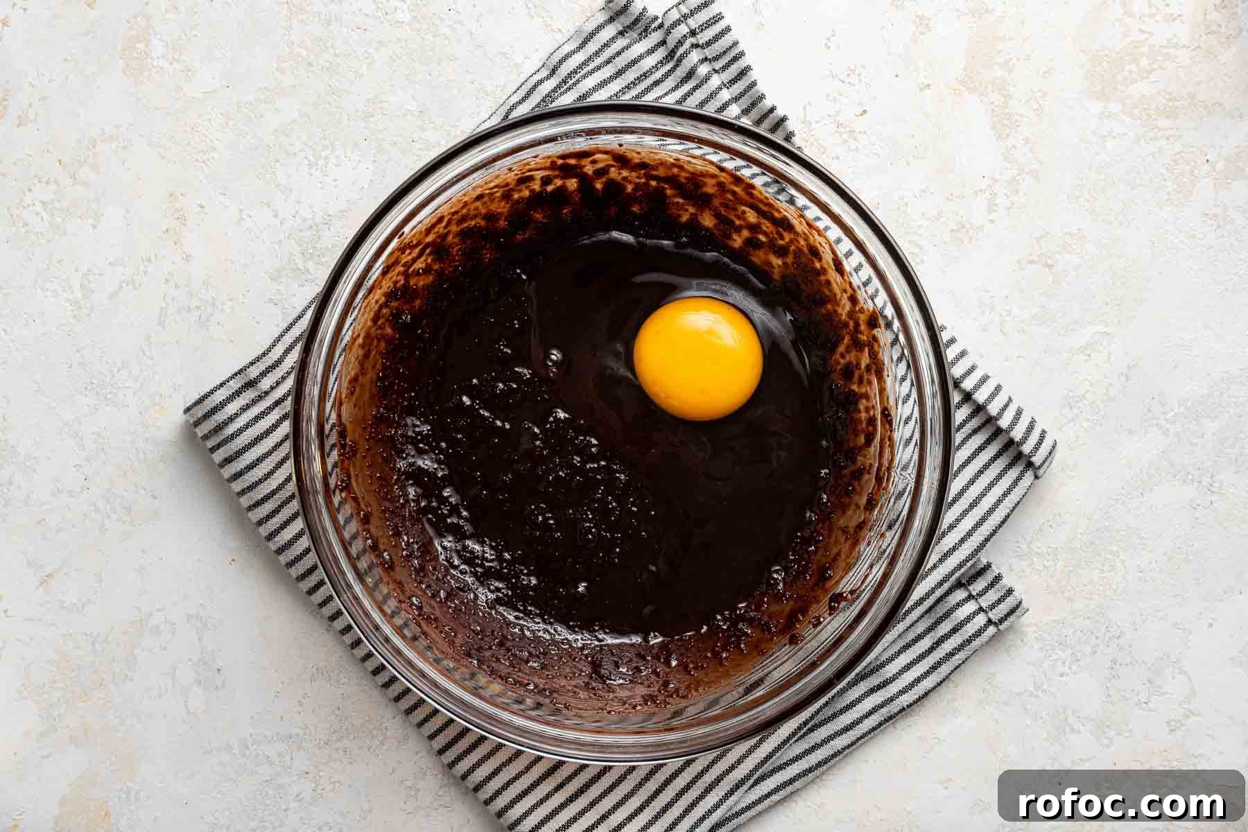 Cheesecake Brownie Bites: Mini Dessert Recipe for Parties 7 Adding a raw egg to brownie batter.