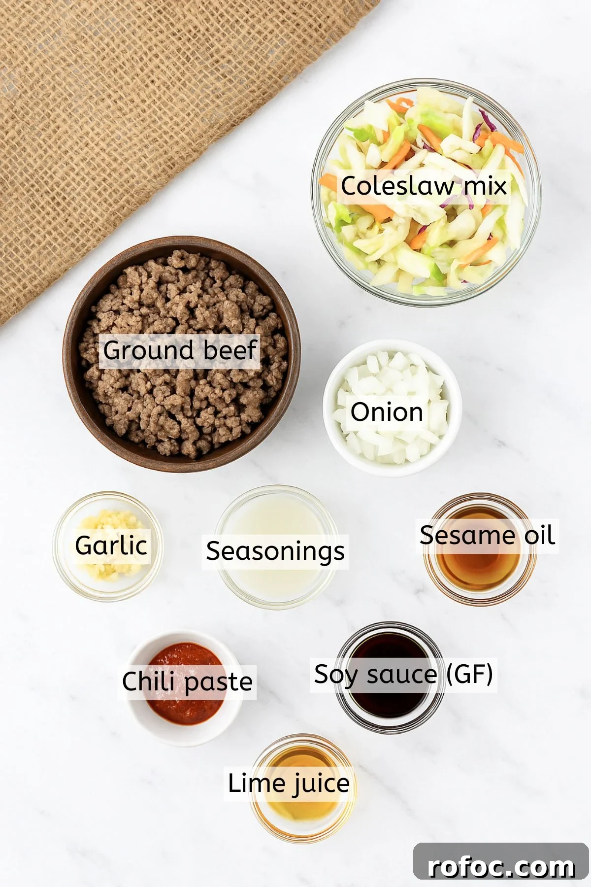 Gluten-Free Inside-Out Egg Roll Recipe for Crispy Flavor 3 Ingredients like ground beef, seasonings, sesame oil, and coleslaw in bowls.