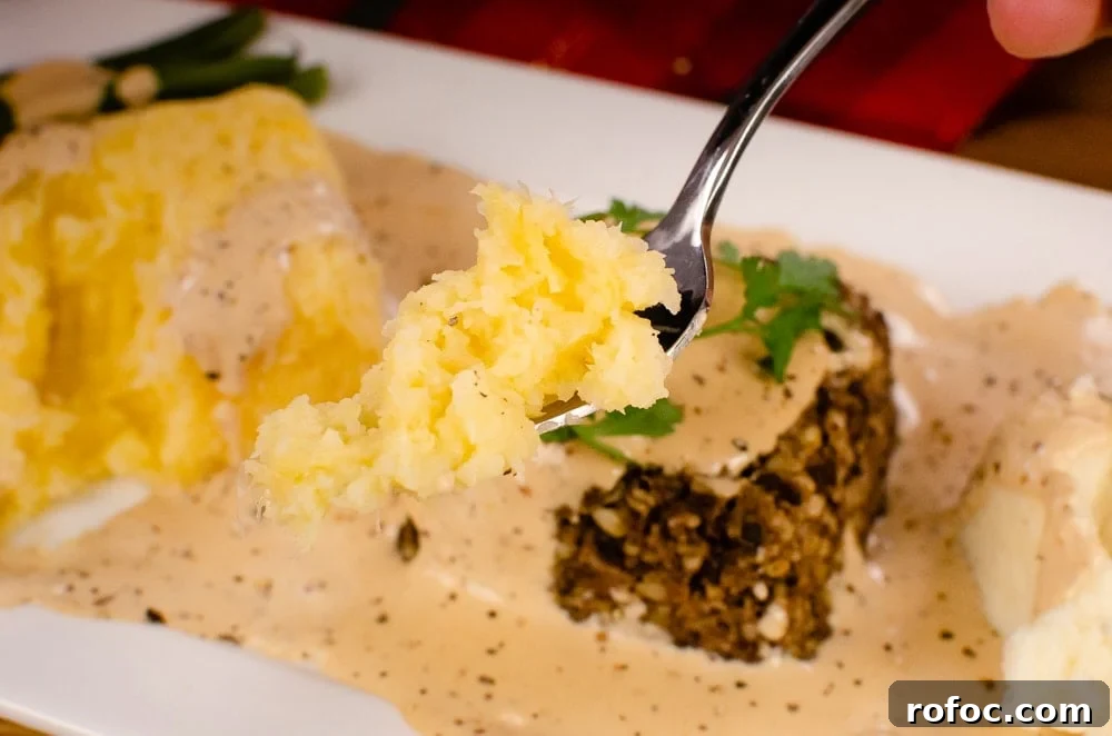 Creamy Buttered Swede on a silver fork served with haggis, creamy mash and whiskey sauce