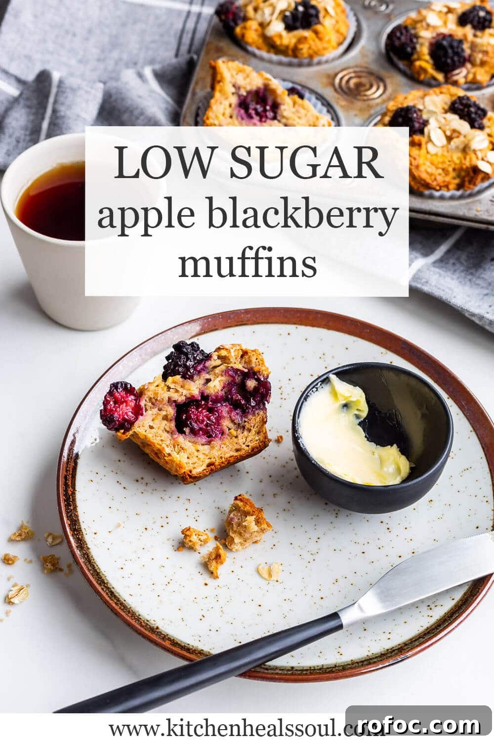 Hearty Apple and Blackberry Muffins Recipe for Fall Baking 2 Low sugar apple blackberry muffins with a vintage muffin pan of baked muffins in the background, a cup of black tea, and a speckled ceramic plate with half a muffin and a dish of butter + knife