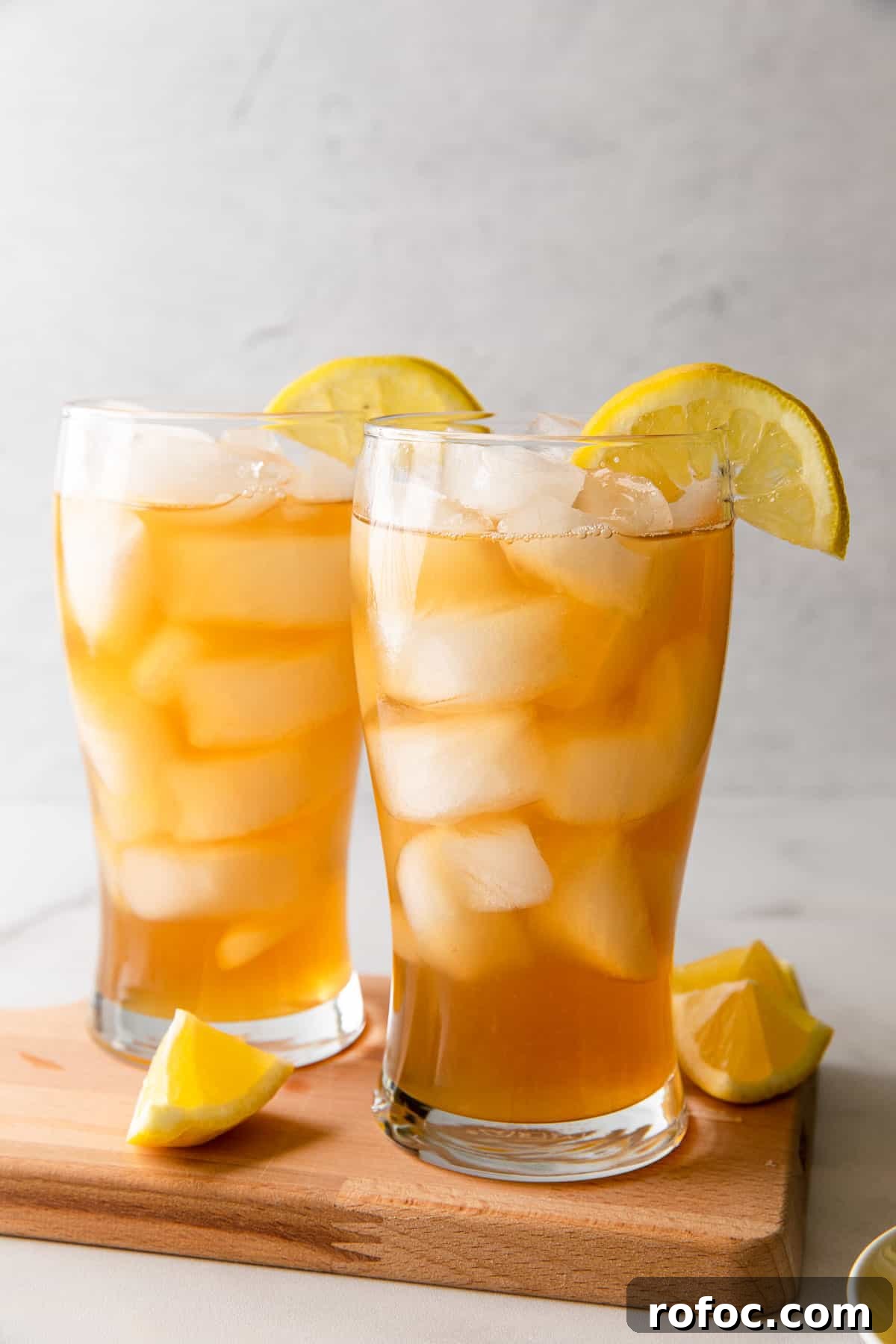 Classic Arnold Palmer Recipe + 3 Refreshing Spiked Variations 14 two glasses of iced tea lemonade with lemon wedges