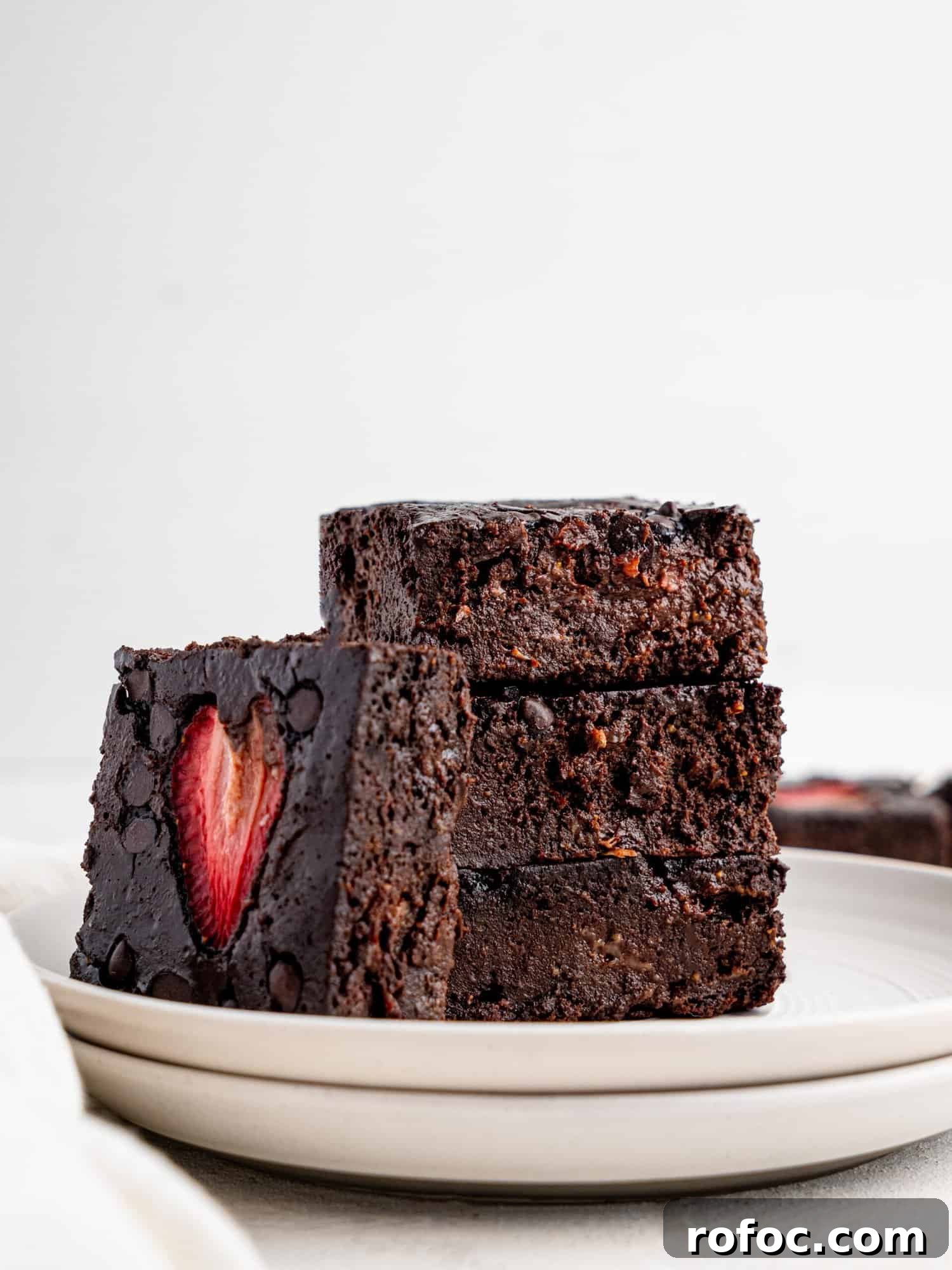 One‑Bowl Strawberry Brownies — Moist, Guilt‑Free Recipe 2 Four brownies with strawberries on a white plate.