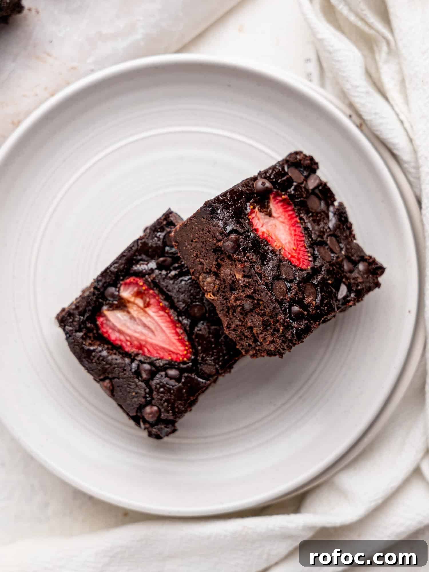 One‑Bowl Strawberry Brownies — Moist, Guilt‑Free Recipe 8 Bird's eye view of two strawberry brownies on a white plate.