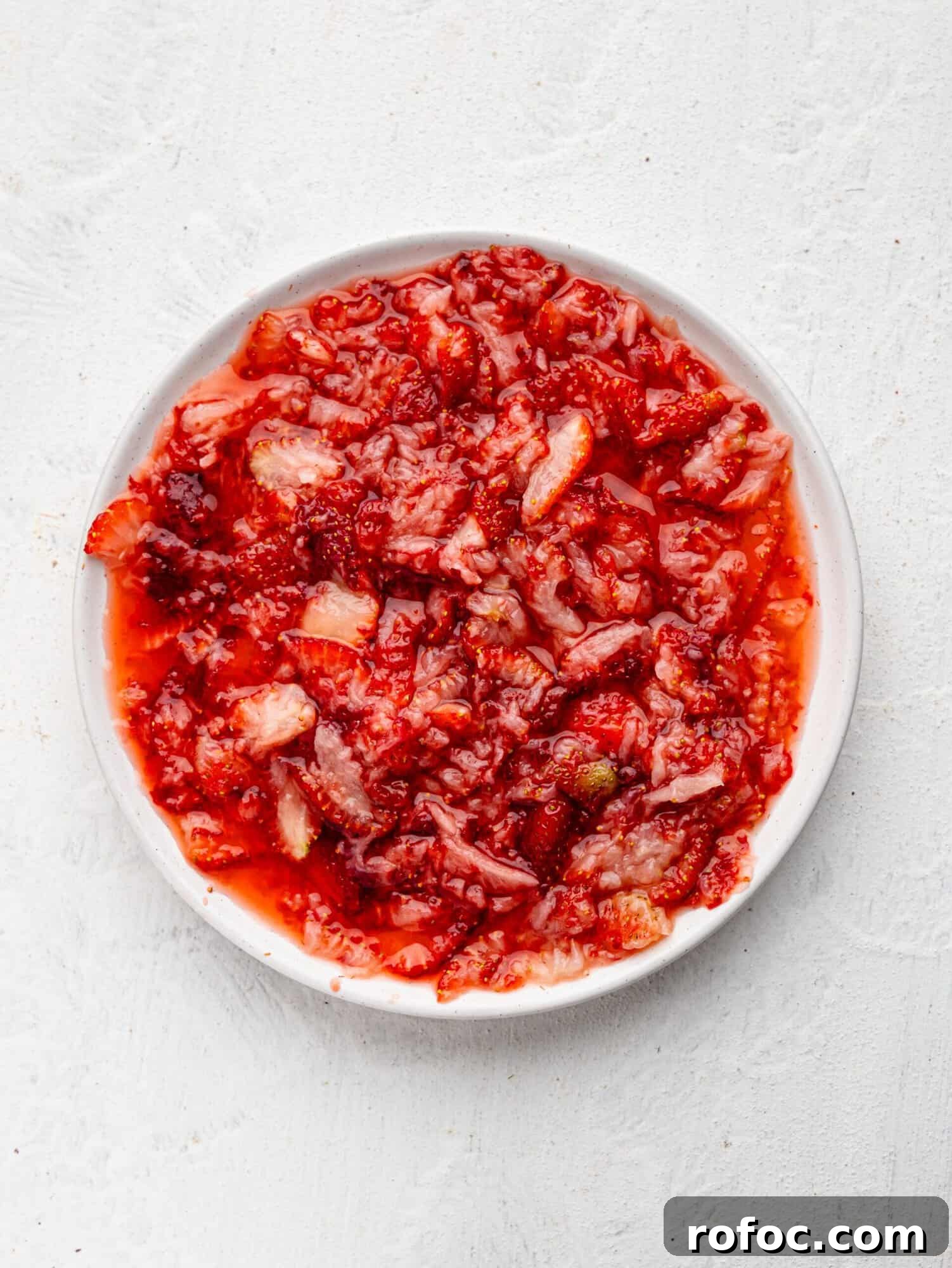 One‑Bowl Strawberry Brownies — Moist, Guilt‑Free Recipe 9 Mashed strawberries on a white plate.
