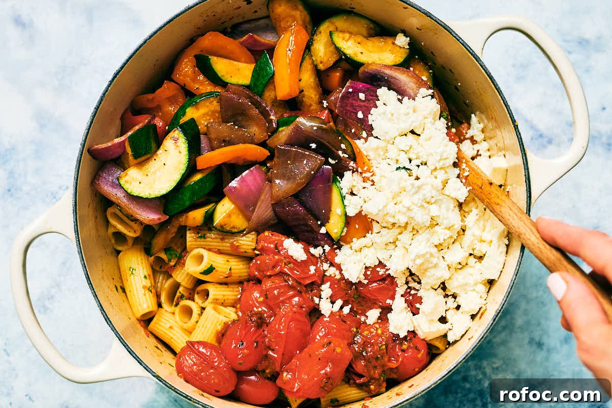 Red Chimichurri Pasta Recipe — Serve Hot or Chilled 12 Red Chimichurri Pasta with feta, sauteed vegetables, and rigatoni being stirred together in a pot.