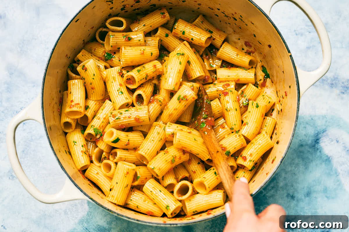 Red Chimichurri Pasta Recipe — Serve Hot or Chilled 13 Rigatoni pasta being tossed in a Red Chimichurri sauce.