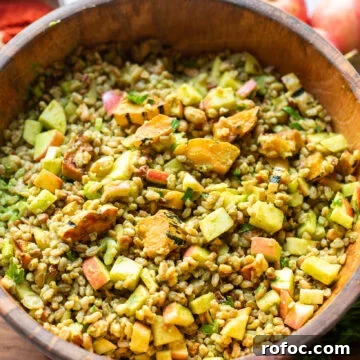 Farro Salad with Apples and Roasted Delicata Squash 7 overhead view of a wooden serving bowl with a marinated grain salad made with apples, delicata squash, pecans, and more in a homemade lemon maple dijon vinaigrette.