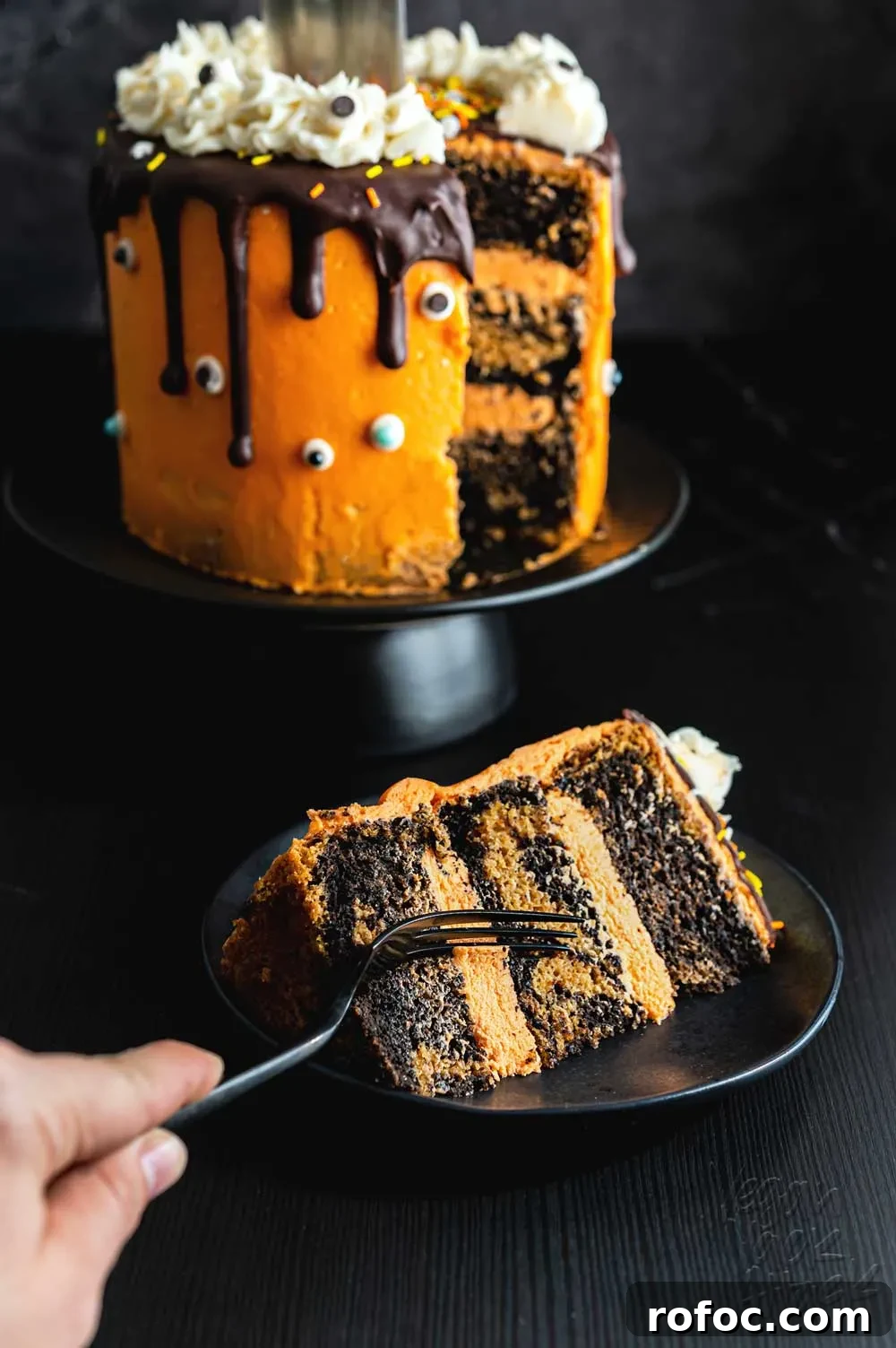 Vegan Pumpkin Chocolate Marble Cake with Silky Ganache 9 Orange frosting covered a marbled layer cake, with a knife sticking out of the top
