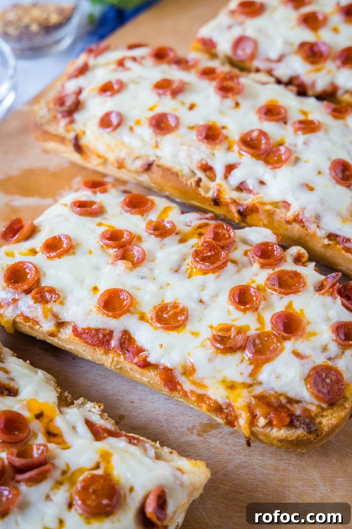 French bread pizzas French bread pizzas on a wooden cutting board.