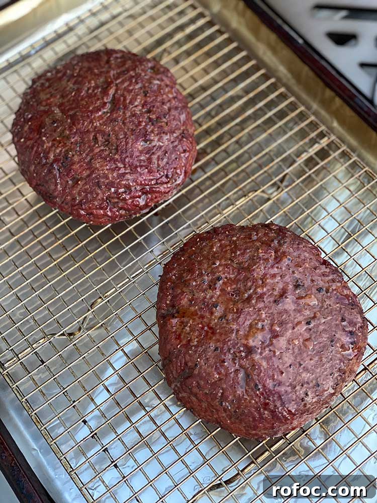 How to Smoke Juicy Hamburgers on a Grill or Smoker 5 smoked burger patties resting on a wire rack