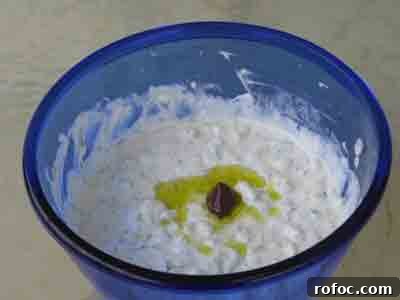 Tzatziki garnished with an olive and olive oil