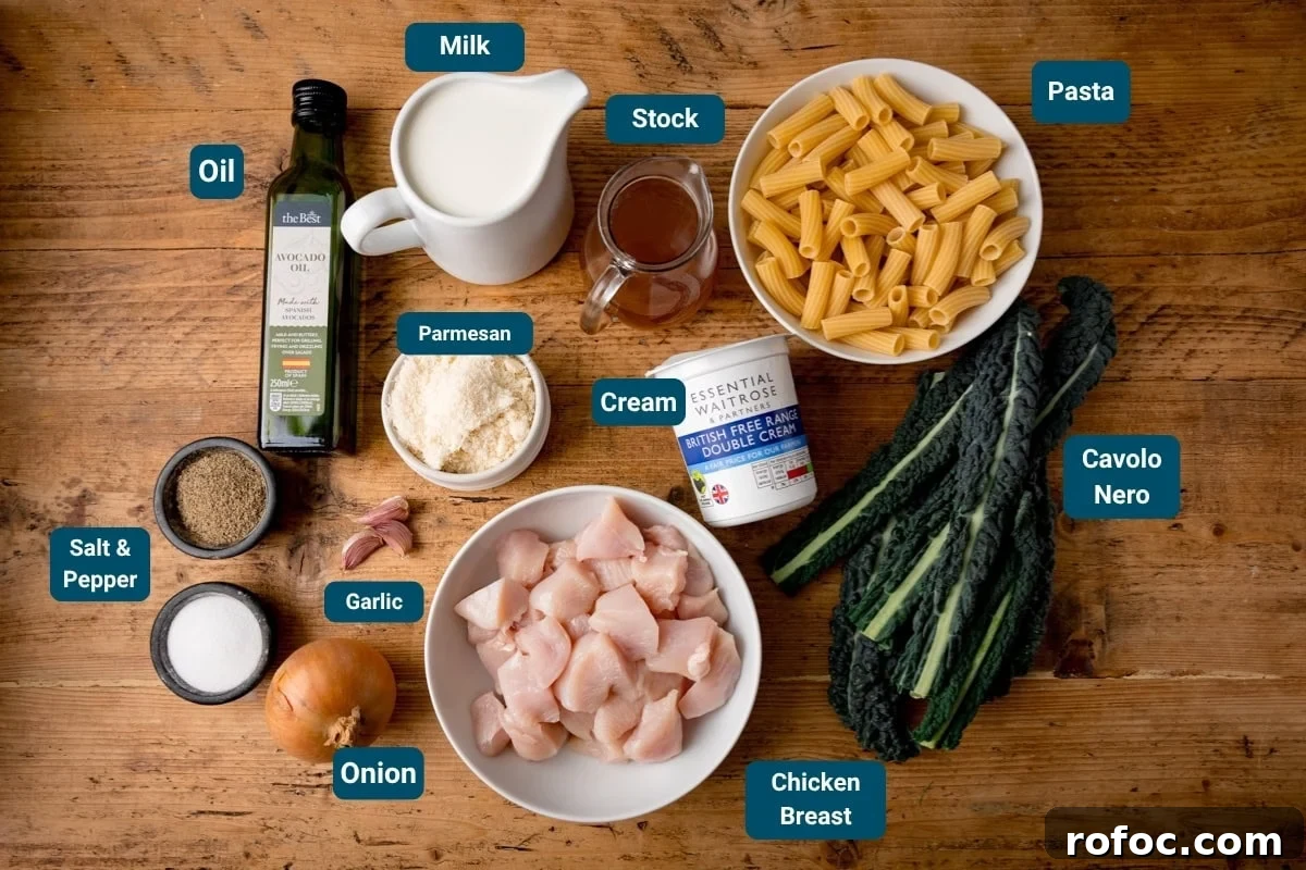 One-Pot Chicken Rigatoni Alfredo Recipe for Creamy Weeknight Meals 4 Ingredients for an alfredo rigatoni pasta dish laid out on a wooden table, including chicken breast, pasta, cavolo nero, onion, garlic, salt & pepper, oil, milk, stock, cream, and parmesan cheese.