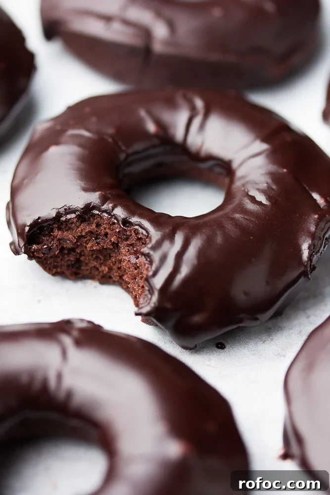 Decadent Vegan Chocolate Donuts Recipe for Perfect Results 2 close up of a chocolate donut with glaze, a bite taken out of it