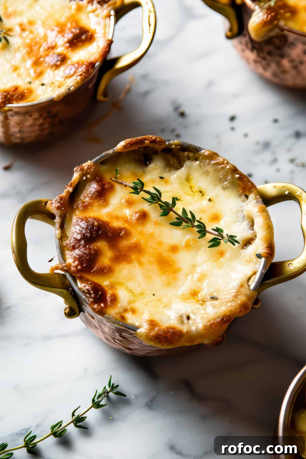 Classic French Onion Soup Recipe with Rich Caramelized Onions 5 Easy french onion soup with melted cheese and fresh thyme leaves in soup bowls.
