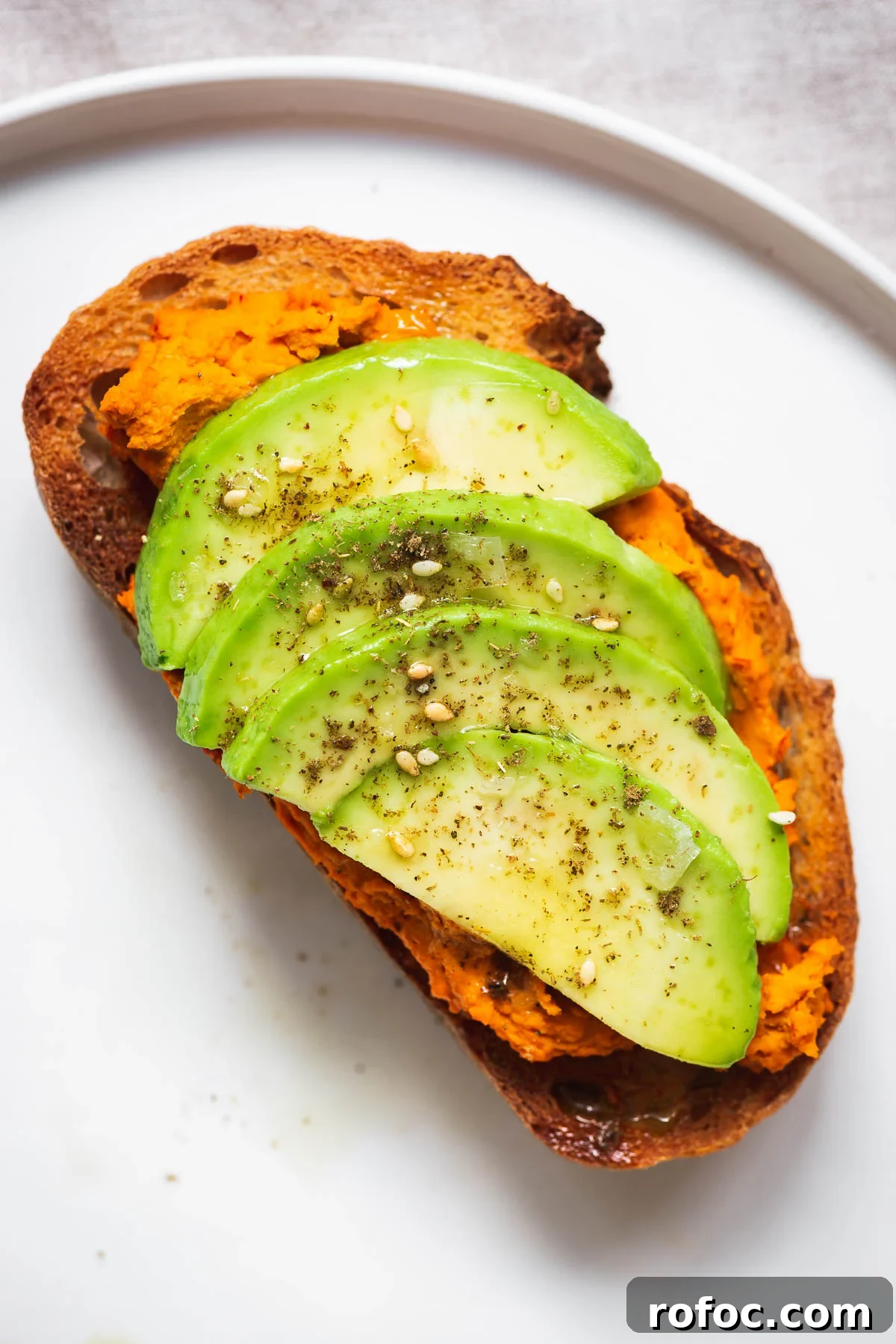 Spicy Harissa Hummus Recipe: Creamy Homemade Dip in Minutes 11 Sourdough toast with harissa hummus and avocado slices.