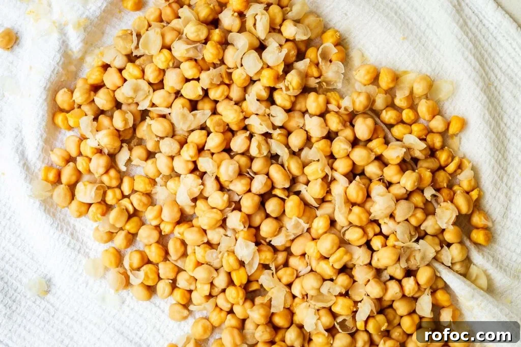 Spicy Harissa Hummus Recipe: Creamy Homemade Dip in Minutes 5 Peeling canned chickpeas by rubbing them in a tea towel.