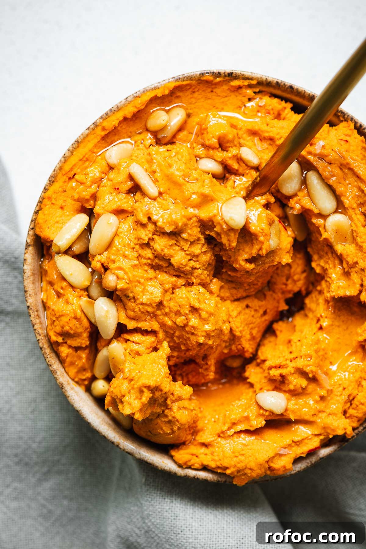 Spicy Harissa Hummus Recipe: Creamy Homemade Dip in Minutes 10 Spicy harissa hummus topped with olive oil and pine nuts.