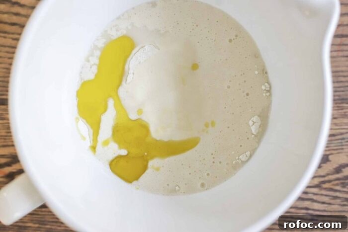 Sourdough Flatbread Recipe Using Active Starter or Discard (No Yeast) 7 sourdough starter, oil, salt, water, and flour in a white ceramic stand mixer bowl