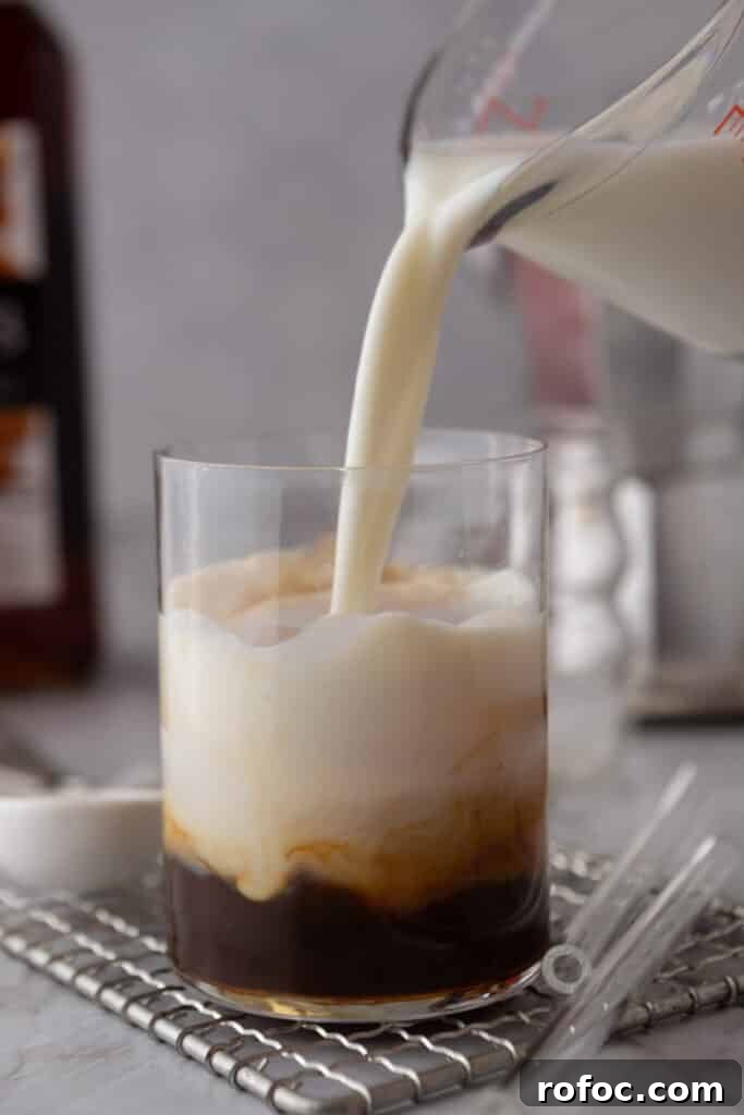 Viral Whole Foods Brown Butter Cookie Latte Recipe for Home Brewing 6 Hand pouring milk into a glass