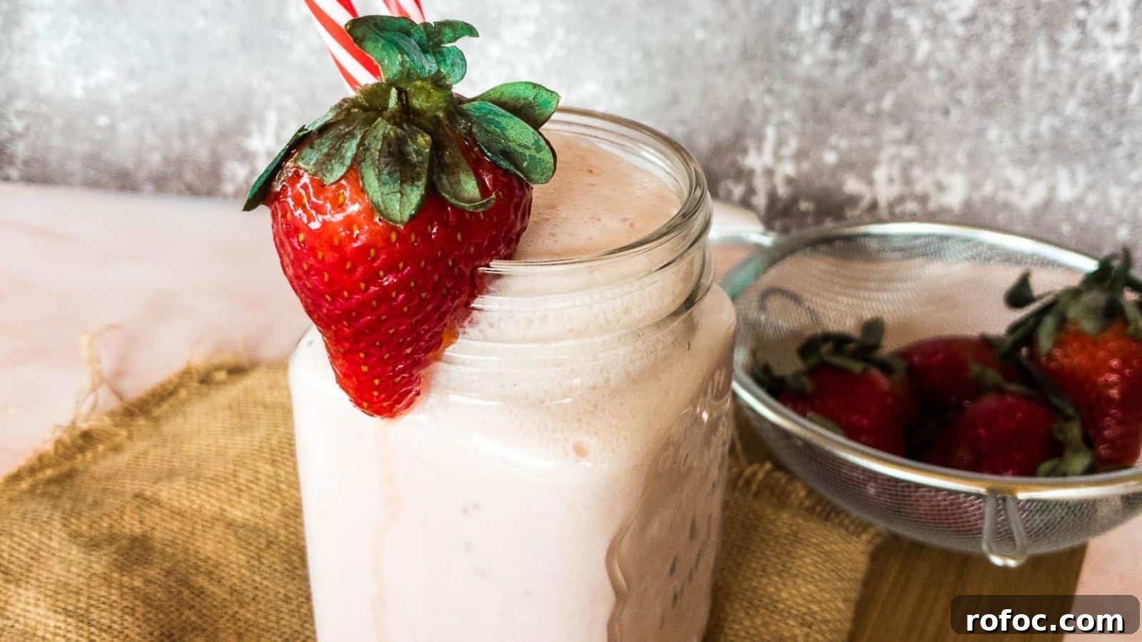 15 Low-Carb Recipes That Taste Like You Spent Hours 14 A glass jar of strawberry smoothie with a whole strawberry on the rim.