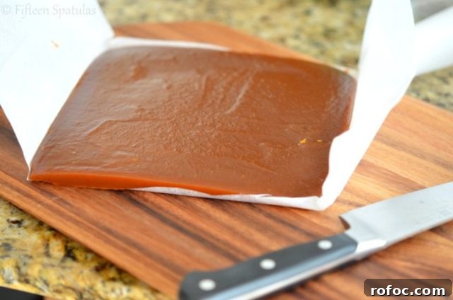 Pumpkin Spice Caramels | fifteenspatulas.com Firm Pumpkin Spice Caramel Square on Cutting Board