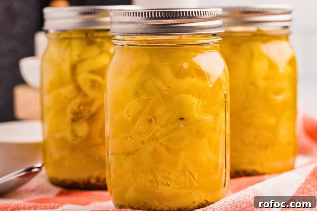 How to Can Homemade Pickled Banana Peppers for Long-Term Storage 10 front close up shot of 3 jars of pickled banana peppers.