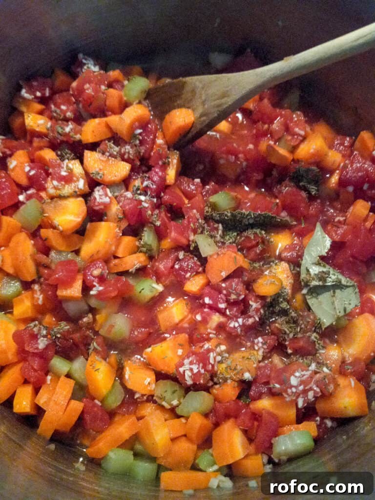 Classic Amish Beef and Barley Soup Recipe for Cozy Meals 3 chopped veggies cooking in a big pot.