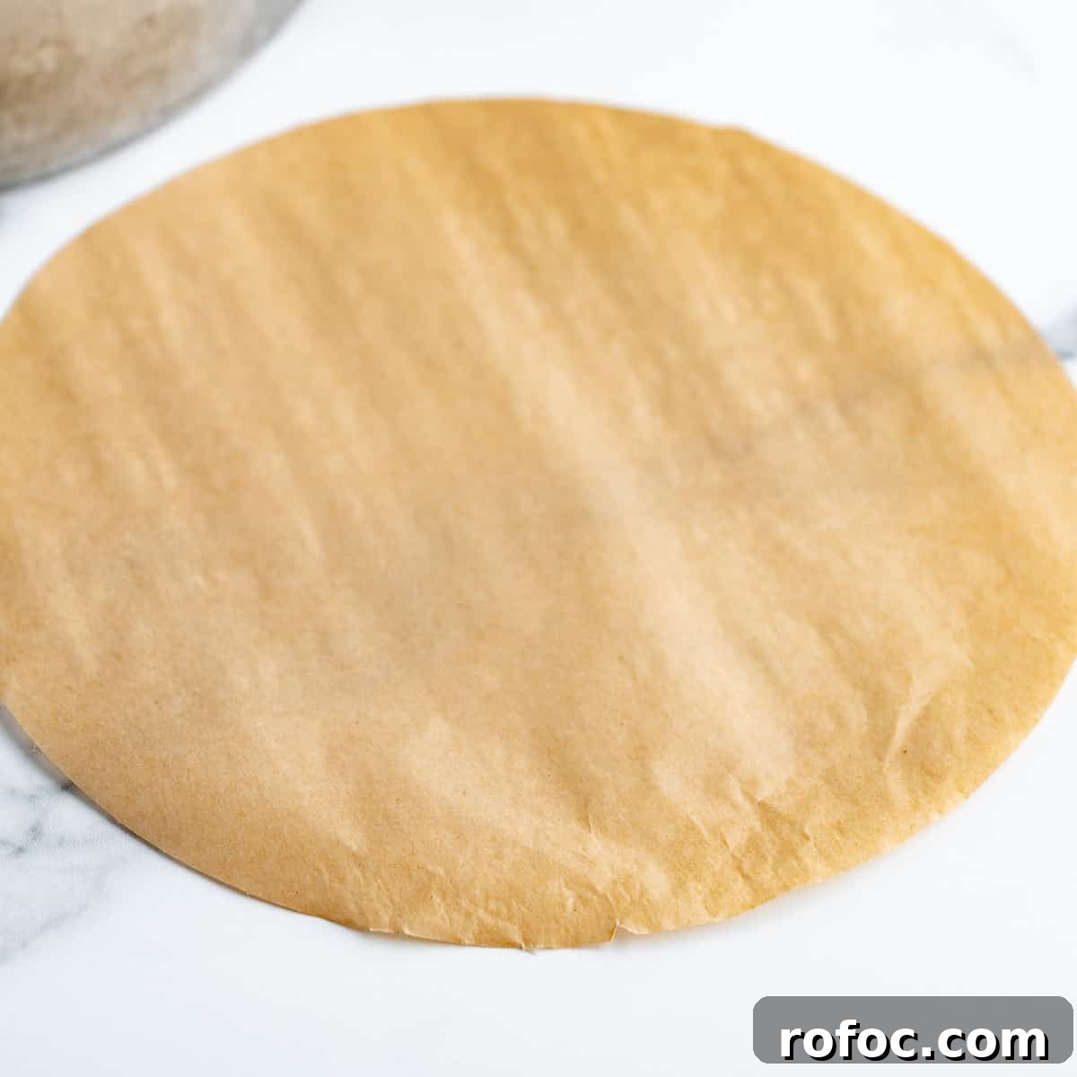 Decadent Cherry Cheesecake Recipe with a Buttery Crust 3 A round brown piece of parchment paper.