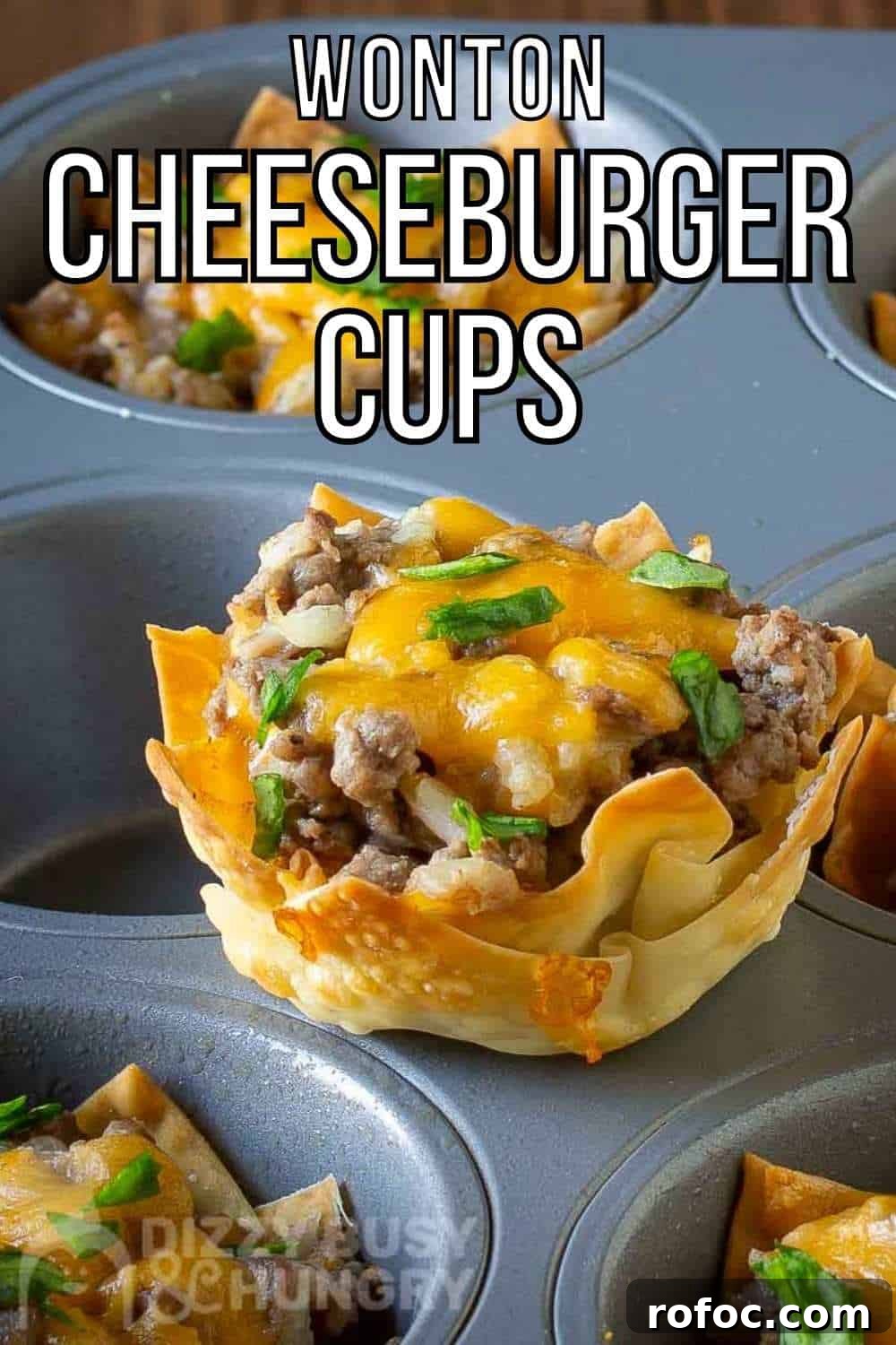 Wonton Cheeseburger Cups: Mini Cheeseburger Bites in Crispy Wrappers 2 Side shot of a wonton cheeseburger cup sitting on a the flat part of a cupcake sheet with more in the background.