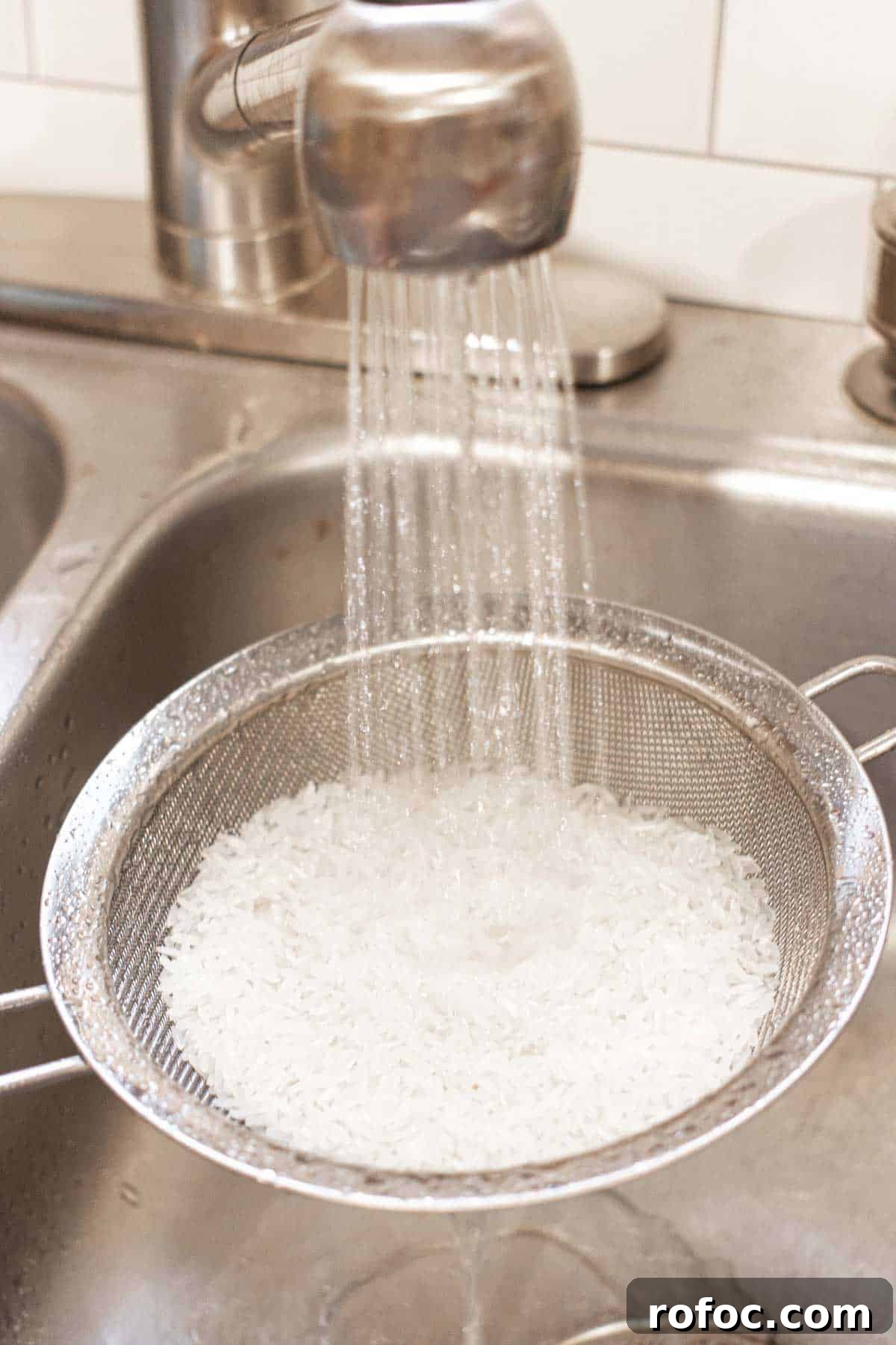 Perfect Jasmine Rice in the Instant Pot: Fluffy & Quick 4 One cup of rice in a large fine-mesh strainer with water from the faucet pouring over the rice.