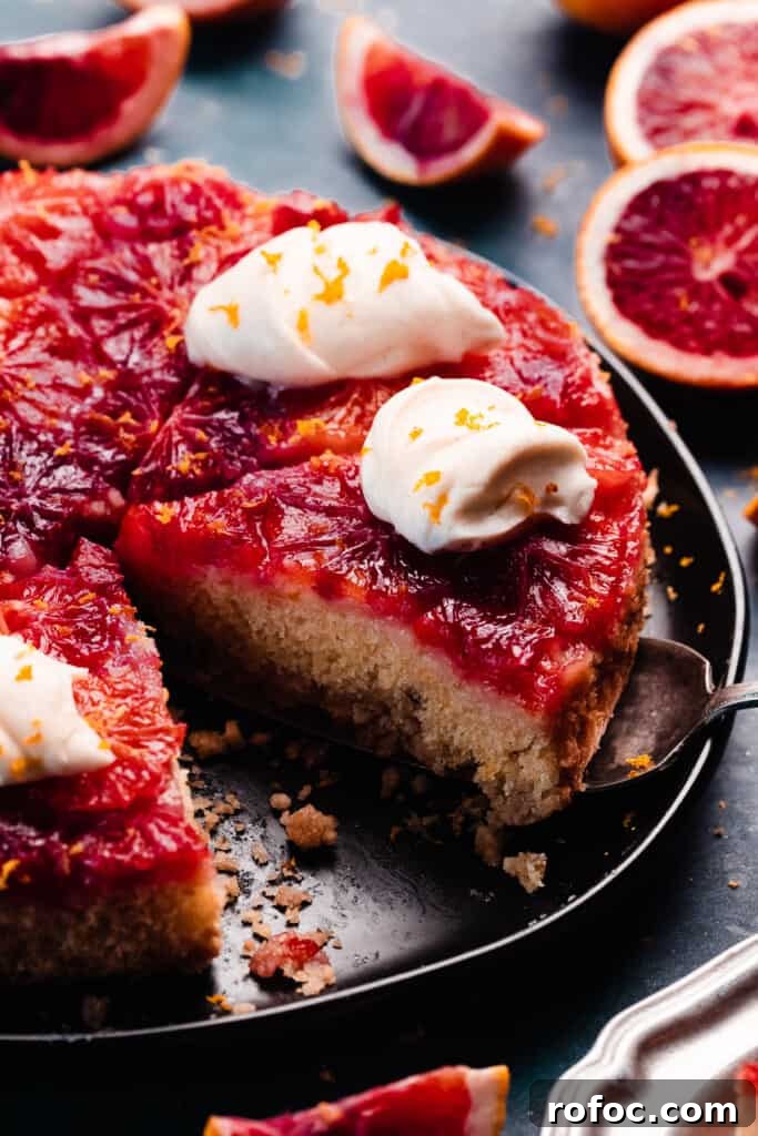 Blood Orange Upside-Down Cake Recipe & Citrus Glaze Tips 2 A slice of orange upside down cake being lifted from the plate with a cake server.