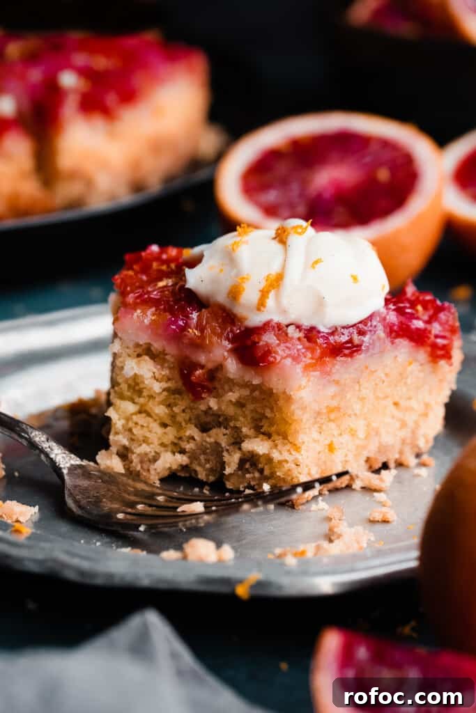 Blood Orange Upside-Down Cake Recipe & Citrus Glaze Tips 11 A close-up of a slice of the cake on a plate, with a bite missing.