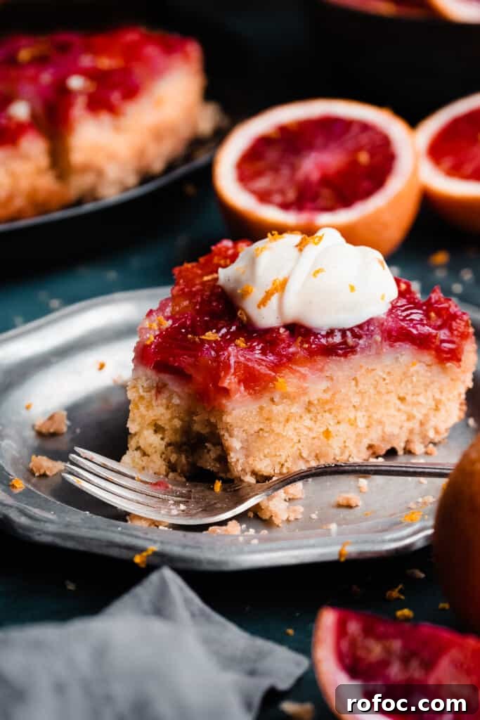 Blood Orange Upside-Down Cake Recipe & Citrus Glaze Tips 3 A slice of the blood orange upside down cake on a plate, with a bite missing.