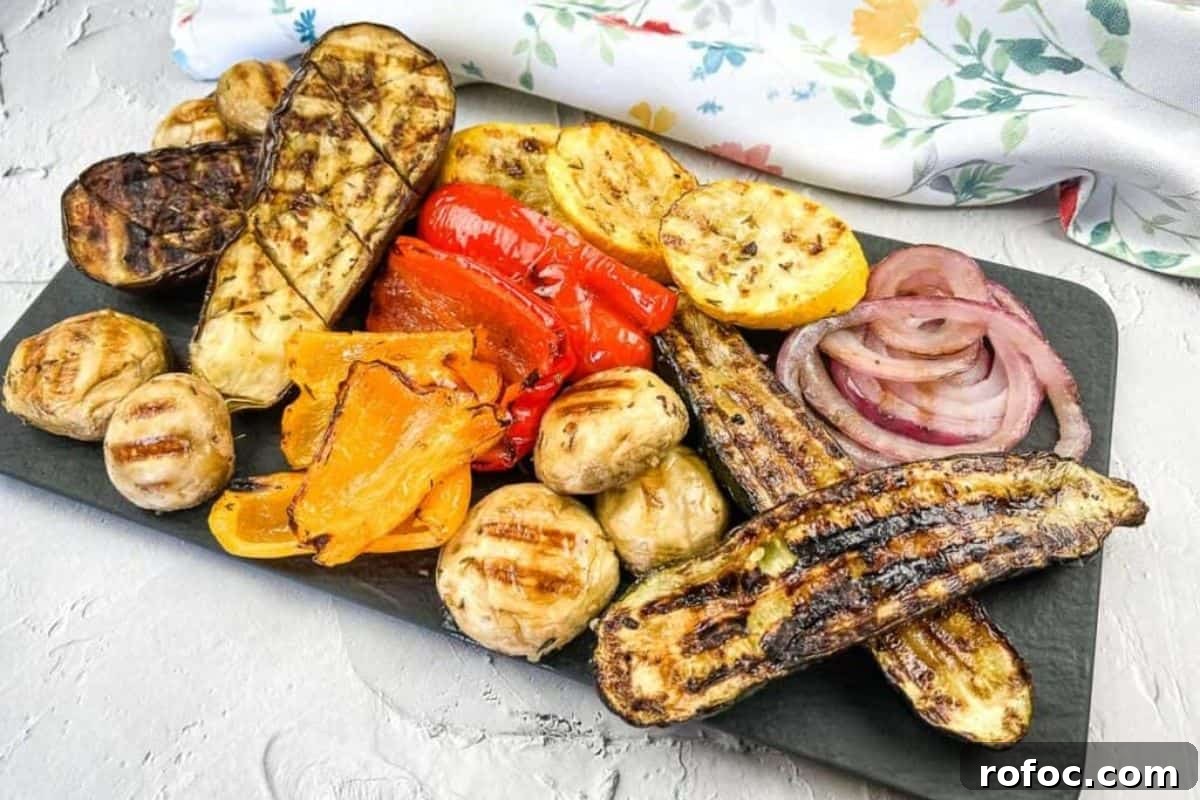 19 Fall Cookout Recipes for Sunday Dinner and Game Day 14 Grilled vegetables including zucchini, mushrooms, red onions, peppers, and squash, arranged on a rectangular black platter.